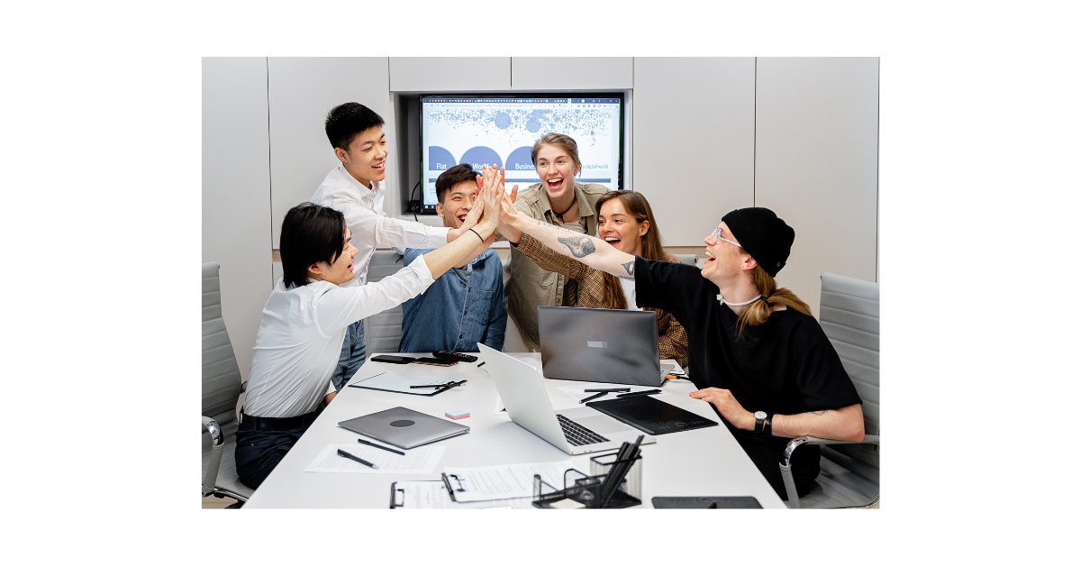 Reunión de equipo analizando ideas para mejorar el negocio con una pantalla de fondo que muestra una bombilla representando innovación empresarial.